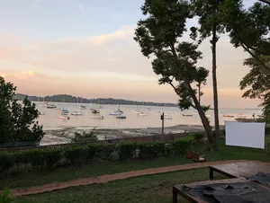 Sunset bay view of moored sailboats from the terrace garden at a Singapore farmstay by the sea, 2D1N stay