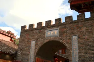 Brick archway in Lijiang’s Old Town, marked with Chinese characters, framed by shop eaves during a guided walk in Shuhe