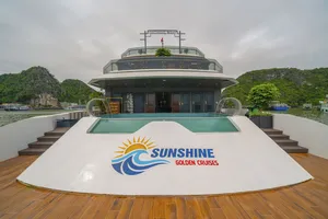 Sunshine Golden Cruises bow pool and upper deck on a luxury Cat Ba cruise, with limestone hills and cloudy skies