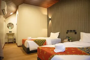 Triple-bed room at Sukau Greenview Lodge for a Kinabatangan River safari night, with neatly laid linens and pillows