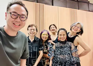 Chong Zheng Calligraphy host with smiling group during Chinese calligraphy introduction in Singapore—ideal for workshops in Singapore