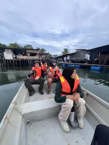 Private tour on a riverboat in Johor Bahru with Young Nautilus educators, guests watching coastal waters past stilt houses