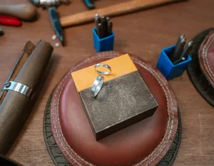Silver ring on a makerâs leather tray and tools laid out on the bench at Fat Anvil Studios in Singapore couple ring workshop