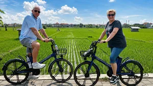 Electric e-bikes paused beside rows of Subak rice fields near Sanur, with Green Bikes Bali guides on a local cycling route