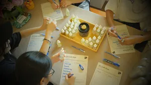 Overhead of a Singapore candle-making table with coco-soy jars and droppers, plus scent cards and bottles in a perfume workshop