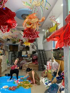Traditional lantern workshop in Saigon with red and gold paper lanterns hanging overhead as makers work at tables in the shop