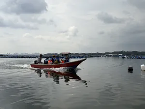Red motorboat carrying passengers through Johor Bahru’s calm coastal waters, part of a private Explore Orang Seletar heritage tour