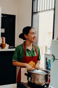 在越南会安的 Jolie 烹饪课上，Jolie 在家中厨房里搅拌锅中的食材