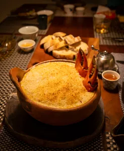 Golden crusted bowl with lobster tails and bread on a communal table at Primateve, private dining Singapore dinner
