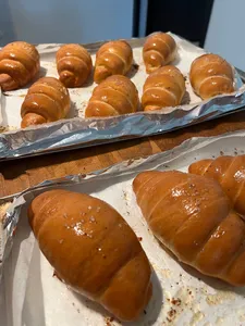 Glossy baked shio pan rolls cooling on a parchment tray during an intimate hands-on class for workshops in Singapore