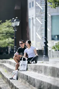 在新加坡河边休息的真人大富翁游戏玩家,带着游戏包微笑合影——新加坡隐藏宝藏