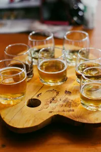 Tibetan brewery tasting in Shangri-La with several glass cups of amber craft beer on a carved wooden board