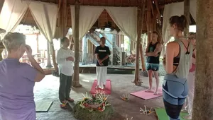 Sacred meditation and cleansing ceremony at Omunity Bali in Bali, with a priest leading a group seated on mats and offerings