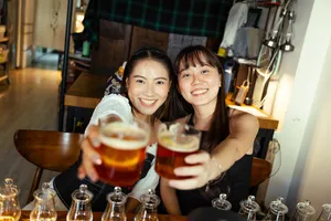 Two guests smiling and clinking amber whisky glasses at a small-batch whisky tasting in a hidden home bar in Singapore