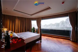Sunshine Golden Cruises cabin with a king bed, floor-to-ceiling curtains and a large window looking out over the water