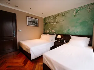 Twin beds in a luxe cabin on a 2D1N Cat Ba cruise with Sunshine Golden Cruises, floral mural feature wall