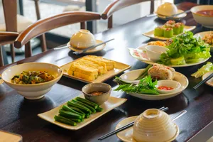 Vietnamese meal spread with bowls, greens, and tofu on a table for an agarwood tour tasting dinner in Hanoi