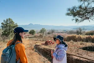 Hikers pausing on a rural trail with mountains in the distance near Lijiang during a Yi & Naxi village trek