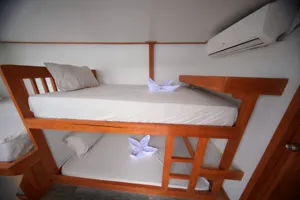 Travass Life 3D2N join-in Komodo trip bunk cabin with ladder, air conditioner and folded towels on the beds, Labuan Bajo