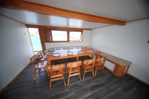 Dining area on a boat with a set table and chairs for a join-in 3D2N Komodo trip, near Komodo Island