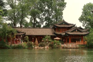 Traditional Naxi wooden buildings and garden courtyard steps beside a lake in Shuhe Ancient Town, Lijiang