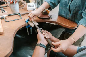Hands polishing a silver ring on a workbench during a couple rings workshop at Fat Anvil Studios in Singapore