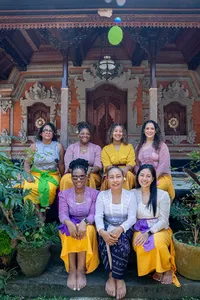 Group of women posing in a Balinese temple courtyard with canang sari offerings during a Ubud, Bali workshop