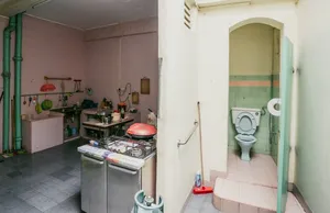 Dapur terbengkalai dengan kompor tua dan pintu menuju toilet, dalam pengalaman Hidden Heritage Behind Jalan Besar’s Doors tentang sudut tersembunyi Singapura