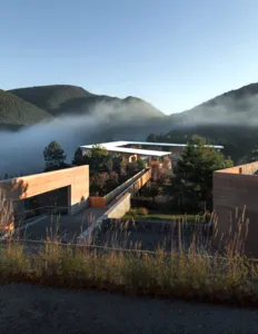 Halaman bangunan eco-retreat modern di Shaxi, Dali, dikelilingi punggung pegunungan berkabut saat fajar, menginap di Linden Centre