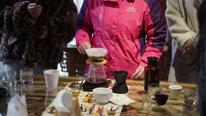Pour-over coffee tasting at a Lijiang workshop: glass carafe, mini drippers and cups on a table as attendees prepare to sample