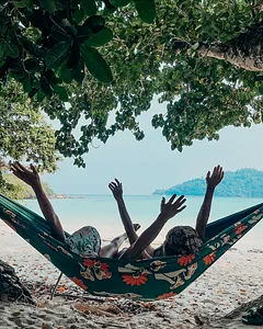 Hammock on the sandy beach of Surin Island, with the Andaman Sea beyond, relaxing under leafy trees near Khao Lak