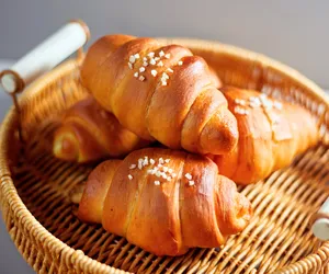 Shio pan rolls with pearl sugar resting in a wicker basket on a table during a Singapore baking workshop