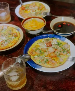 Pengalaman cita rasa budaya di Chan Dat Living Room, Hoi An, dengan gelas wain, mangkuk sup dan pembuka selera terhidang di atas meja makan
