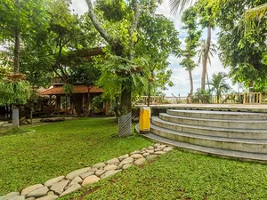 Terraced garden steps and grass lawn framed by tropical trees at Omunity Bali retreat in Bali for quiet meditation