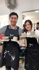 Pottery workshop at a studio in Joo Chiat Place, Singapore, with two students holding handmade ceramic pieces — workshops in Singapore