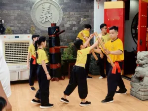 Ho Chi Minh City lion dance troupe practising coordinated stances with tall wooden poles inside a kung fu training room