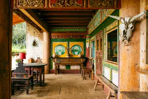 Traditional Tibetan-style dining room with carved furniture and colourful murals at a Mission Liotard base near Shangri-La
