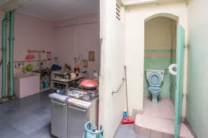 Abandoned kitchenette with a gas stove and tiled toilet in a Jalan Besar building, Singapore hidden gems