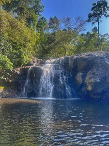 Waterfall cascading into a calm pool in Khao Yai National Park, framed by jungle trees on a wildlife trekking day trip