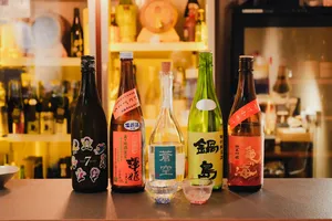 Assorted rare sake bottles and tasting glasses arranged on the counter in a Singapore shop, ready for a guided pour