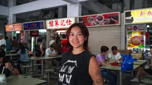 Chef Jenny Dorsey Culinary Consulting smiling by a Singapore hawker centre stall, with diners and signage nearby — Singapore hidden gems