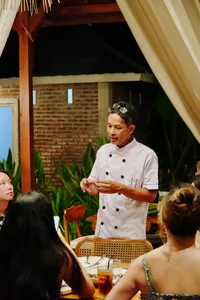Chef Michael instructing guests during a Traditional Manggarai vegan cooking class, speaking in Labuan Bajo