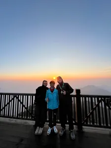 Travellers posing on a balcony at sunset above Sapa after a guide-led 1-day eco trek viewpoint, Mt Fansipan