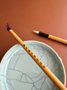Chinese calligraphy brush laid on a blue ceramic dish for practising strokes at Chong Zheng Calligraphy—workshops in Singapore