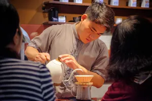 Tea poured during the Rare Agarwood Tour in Hanoi, with tasting cups and a traditional teapot at the host-led session by Up Travel Vietnam