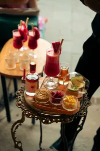 会安，装饰托盘上的红色鸡尾酒，配西瓜装饰、烈酒瓶和开胃小食