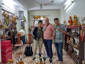 游客在河内一间摆满木偶的工作室里摆姿势拍照,演出开始前,四周环绕着色彩缤纷的水上木偶和舞台人偶