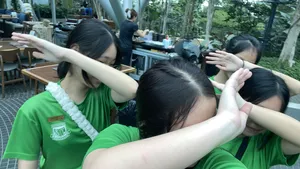 Team members in green T-shirts huddling with hands over their eyes during a team treasure hunt at Marina Central, Singapore hidden gems