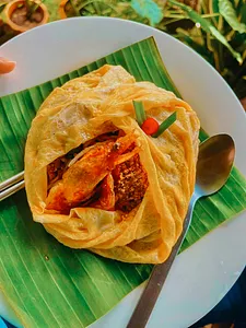 Crispy Thai seafood parcels wrapped in dough, served on a banana-leaf lined plate during a Khao Lak community meal