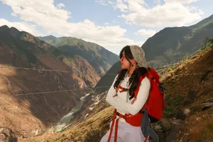Backpacked hiker gazing over a mountain valley on the high trail of Tiger Leaping Gorge, Lijiang, hosted by The Bivou Lijiang